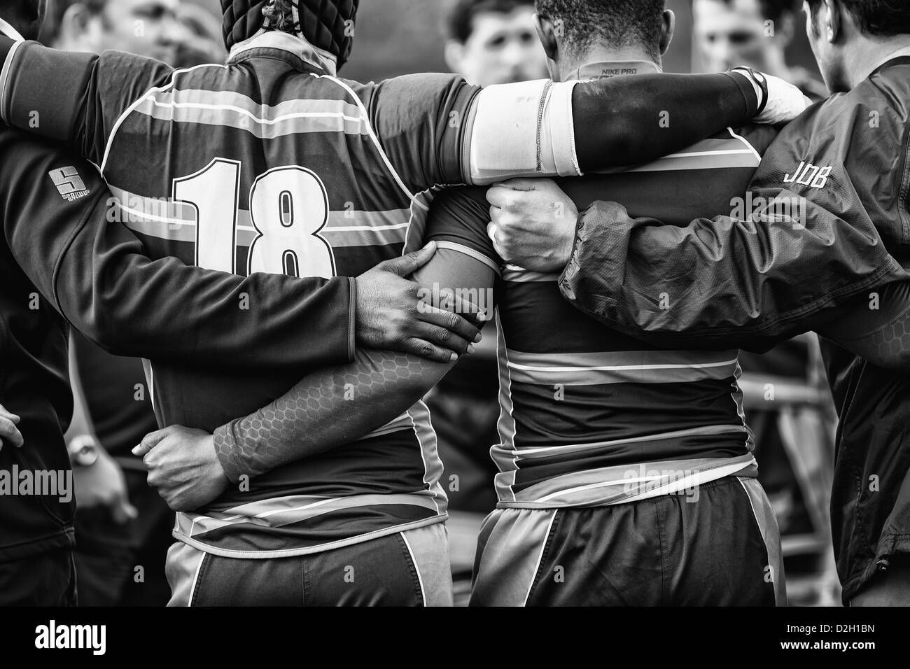 Rugby players huddle after a match Stock Photo