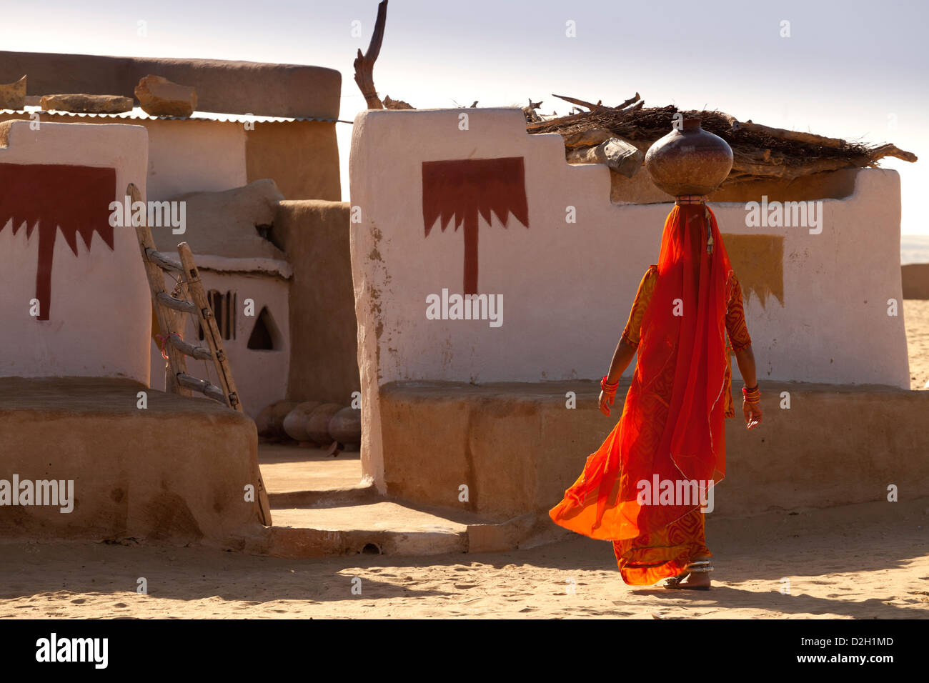 India, Rajasthan, Thar Desert, Indian woman carrying traditional water pot back to village home Stock Photo