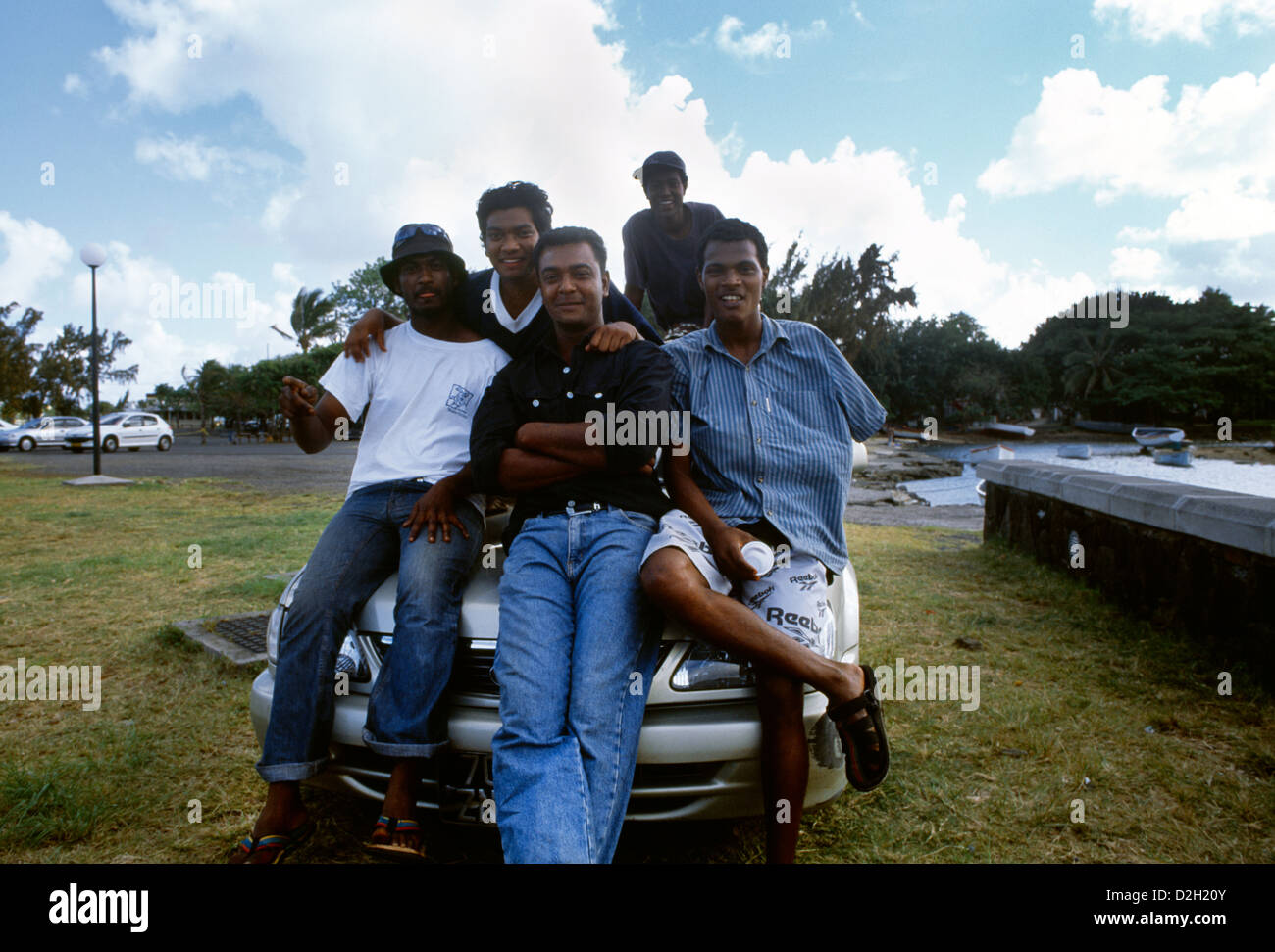 Mahebourg Mauritius Group Of Men Sitting On The Bonnet Of A Car Smiling Stock Photo