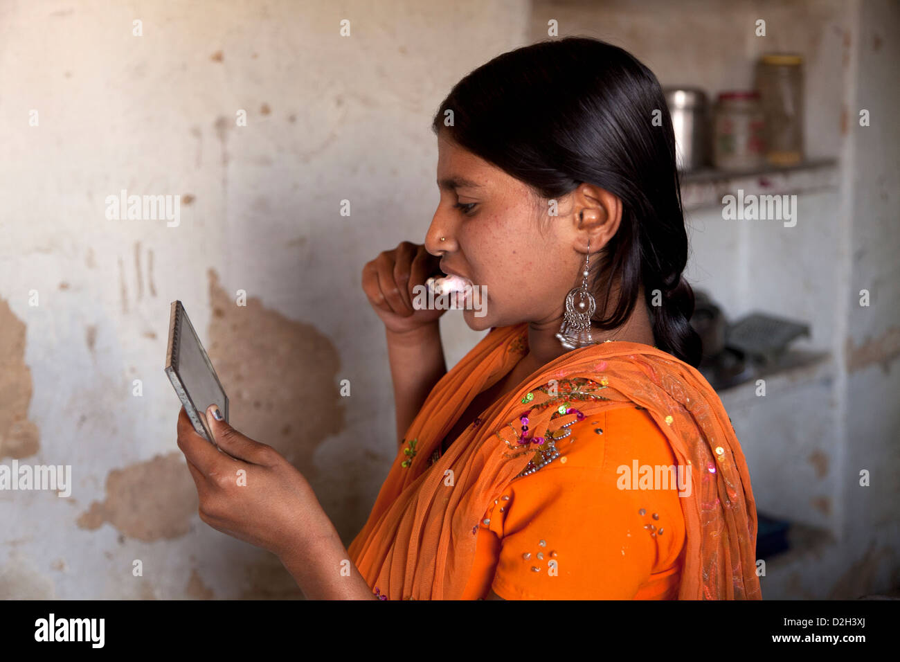 India, uttar Pradesh, Agra Teenage girl brushing teeth with clear evidence of mosquito bites on face Stock Photo