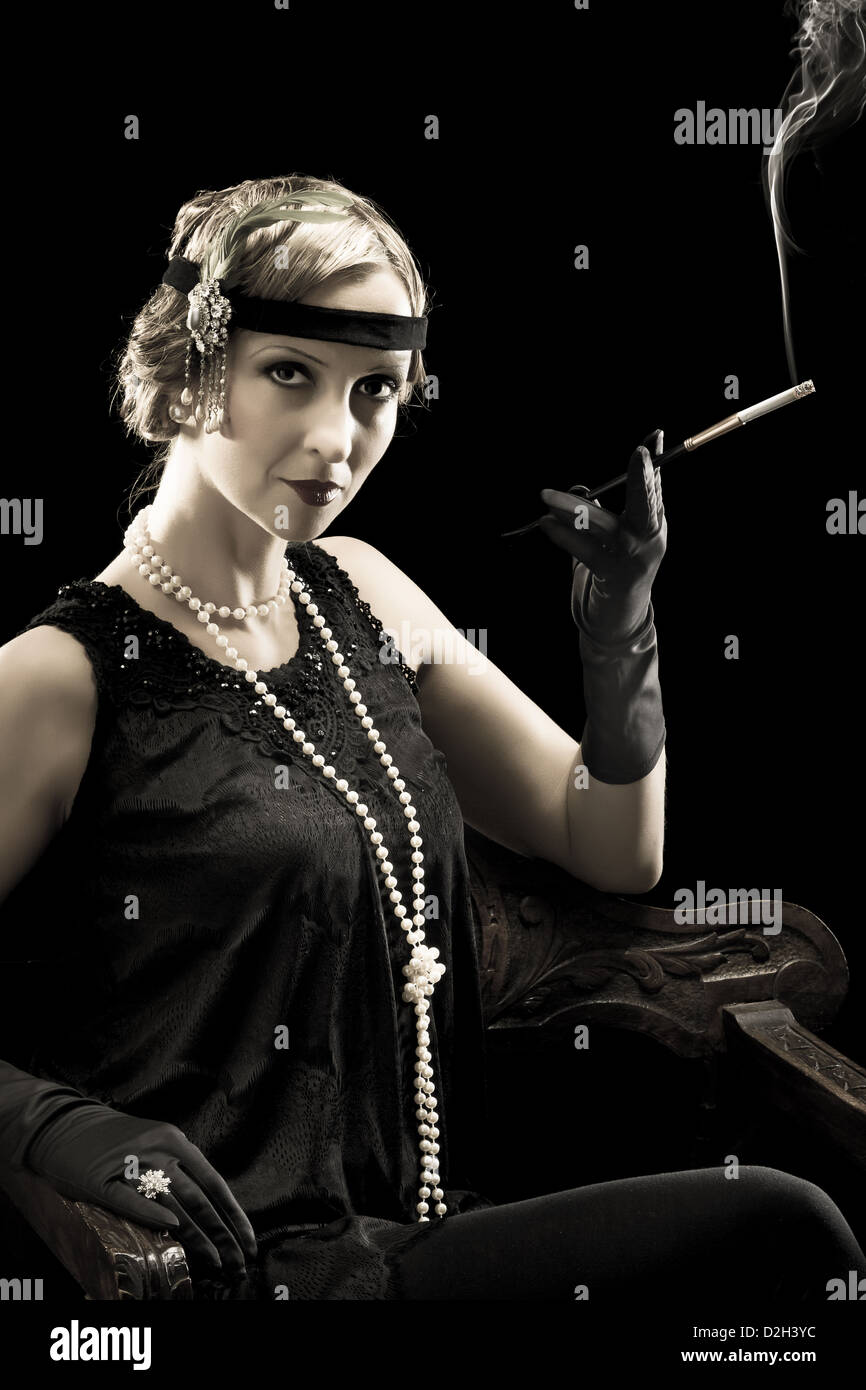 Twenties lady smoking a cigarette with a cigarette holder Stock Photo