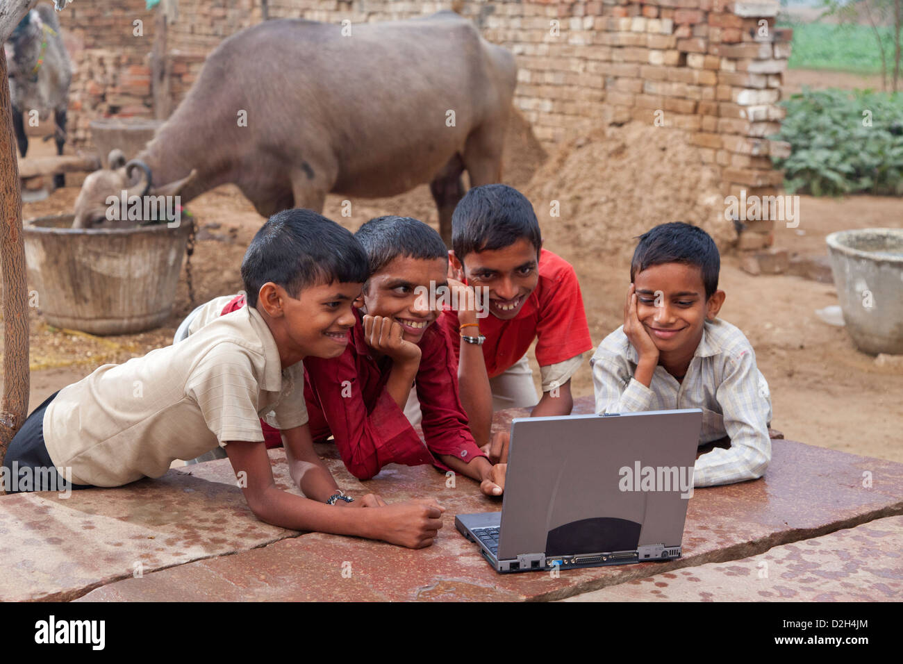 india, Uttar Pradesh, four village children looking at laptop computer