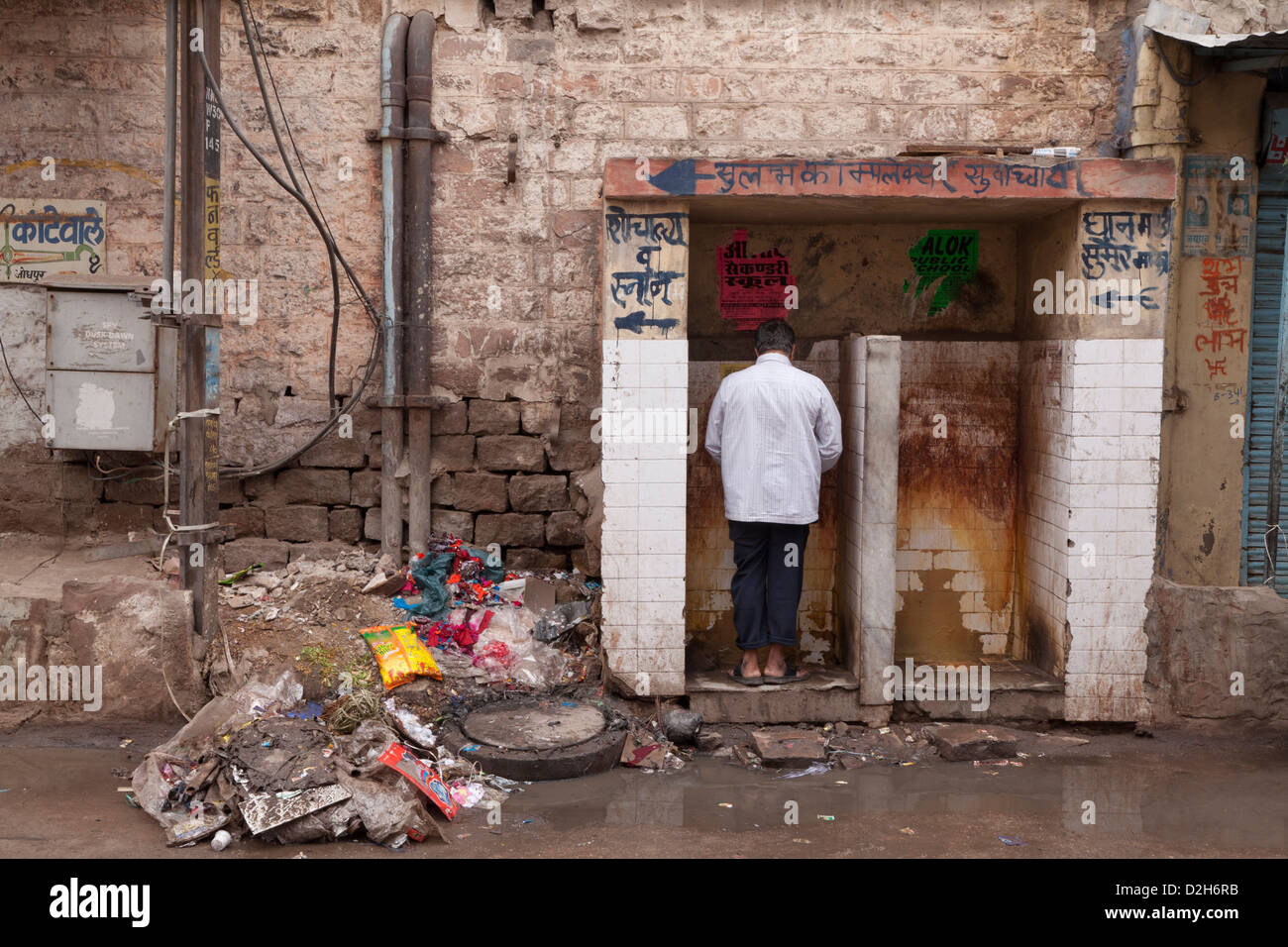 India, Rajasthan, Jodhpur man using unhygienic public toilet surrounded