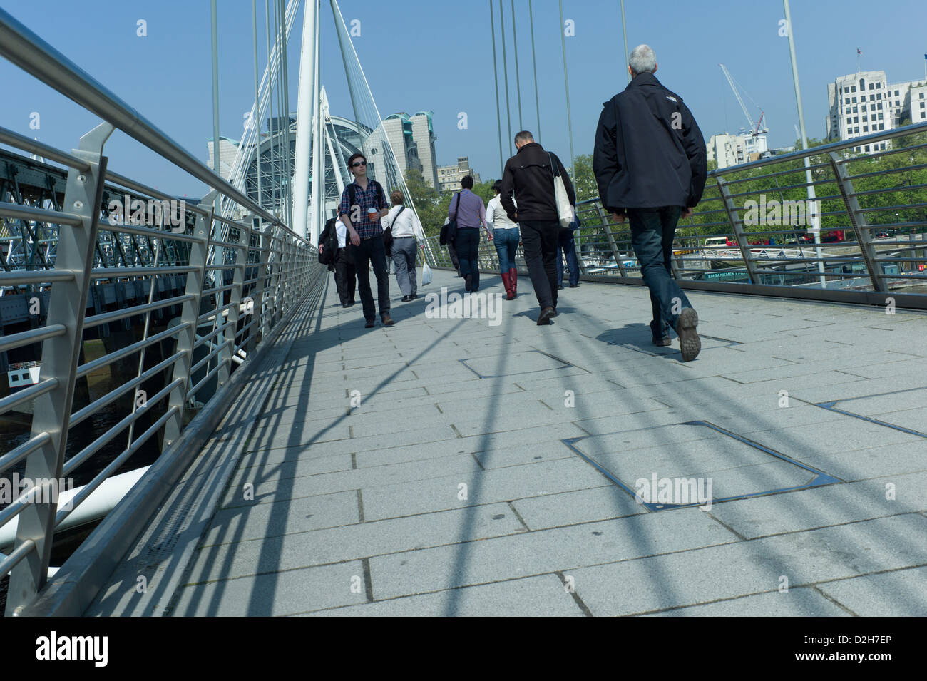 London, Southbank, Riverside, Embankment, Hungerford Bridge commuters tourists walking across bridge on a sunny day Stock Photo