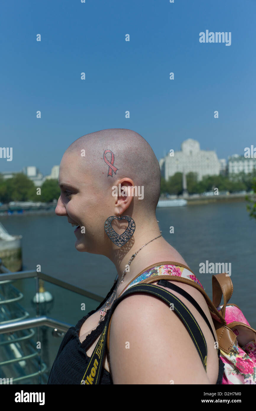 London, Southbank, Riverside, Embankment American US USA tourists  shaved bald head with tattoo supporting cancer Stock Photo