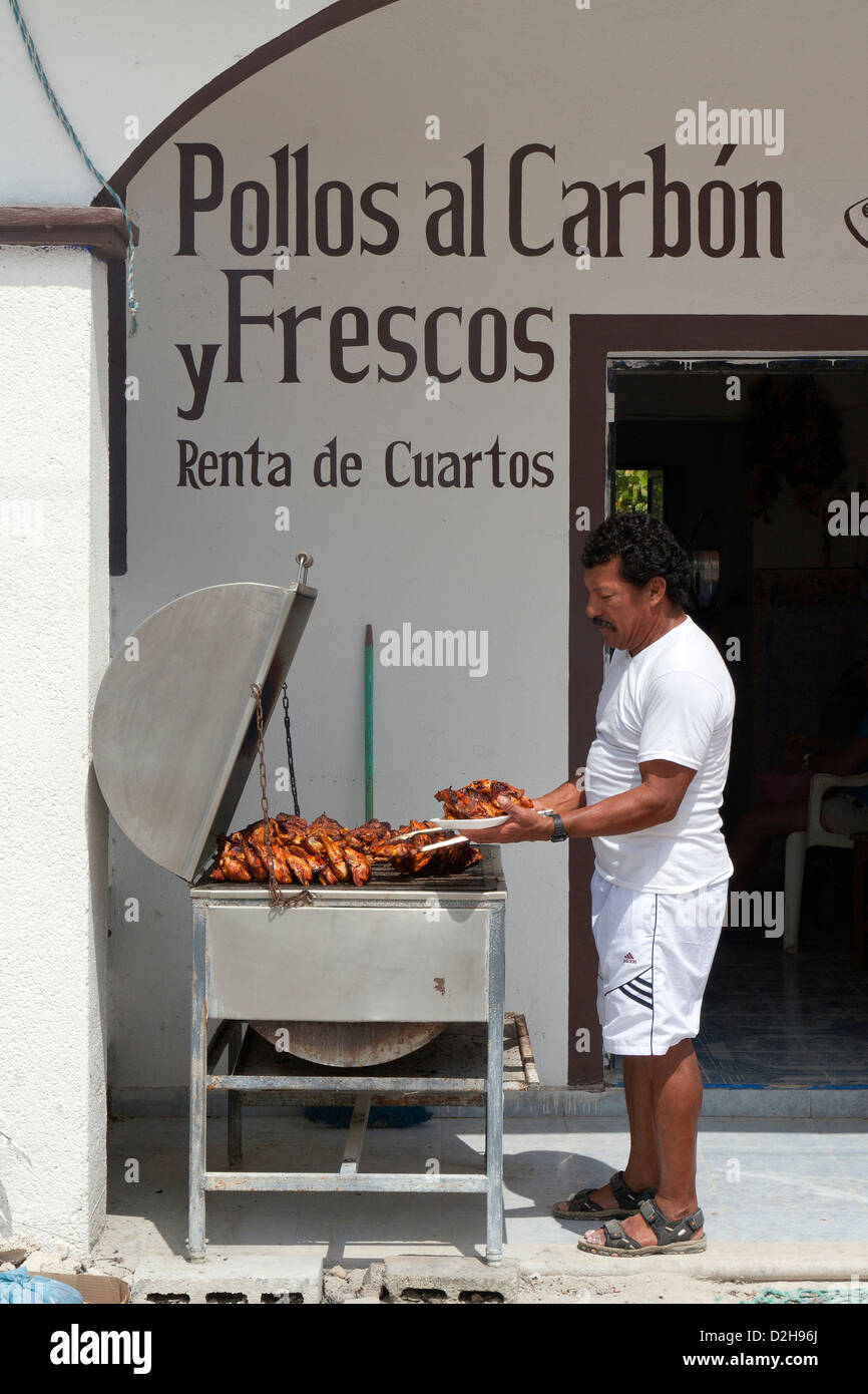 Cook  barbecuing chicken on an outdoor grill in Isla Holbox, Mexico. Stock Photo
