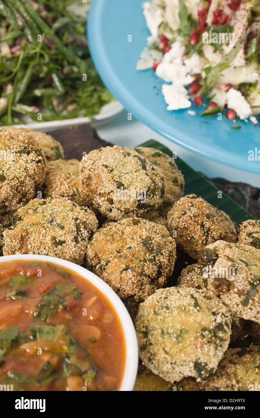 Fishcakes with spicy tomato and basil sauce, fennel and feta with pomegranate seeds at Yotam Ottolenghi restaurant, London UK Stock Photo
