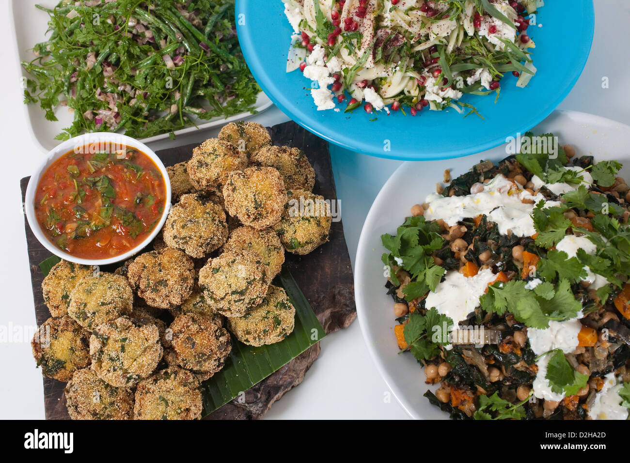 Fishcakes with spicy tomato and basil sauce, fennel and feta with pomegranate seeds at Yotam Ottolenghi restaurant, London UK Stock Photo