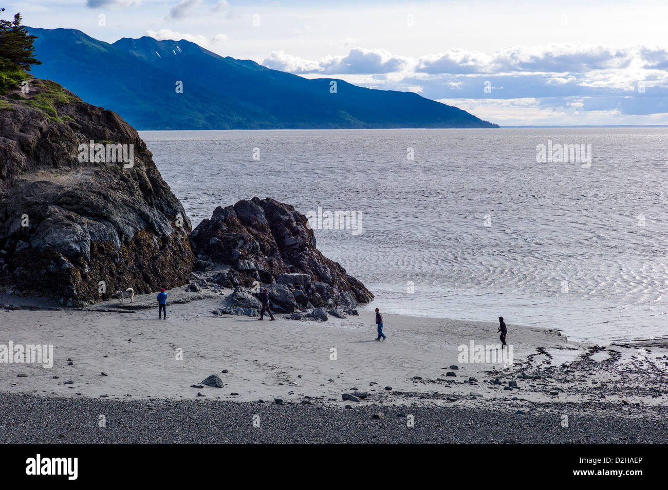 People walk along the beach and rugged landscape of sea and mountains, Turnagain Arm, south of Anchorage, Alaska, USA Stock Photo