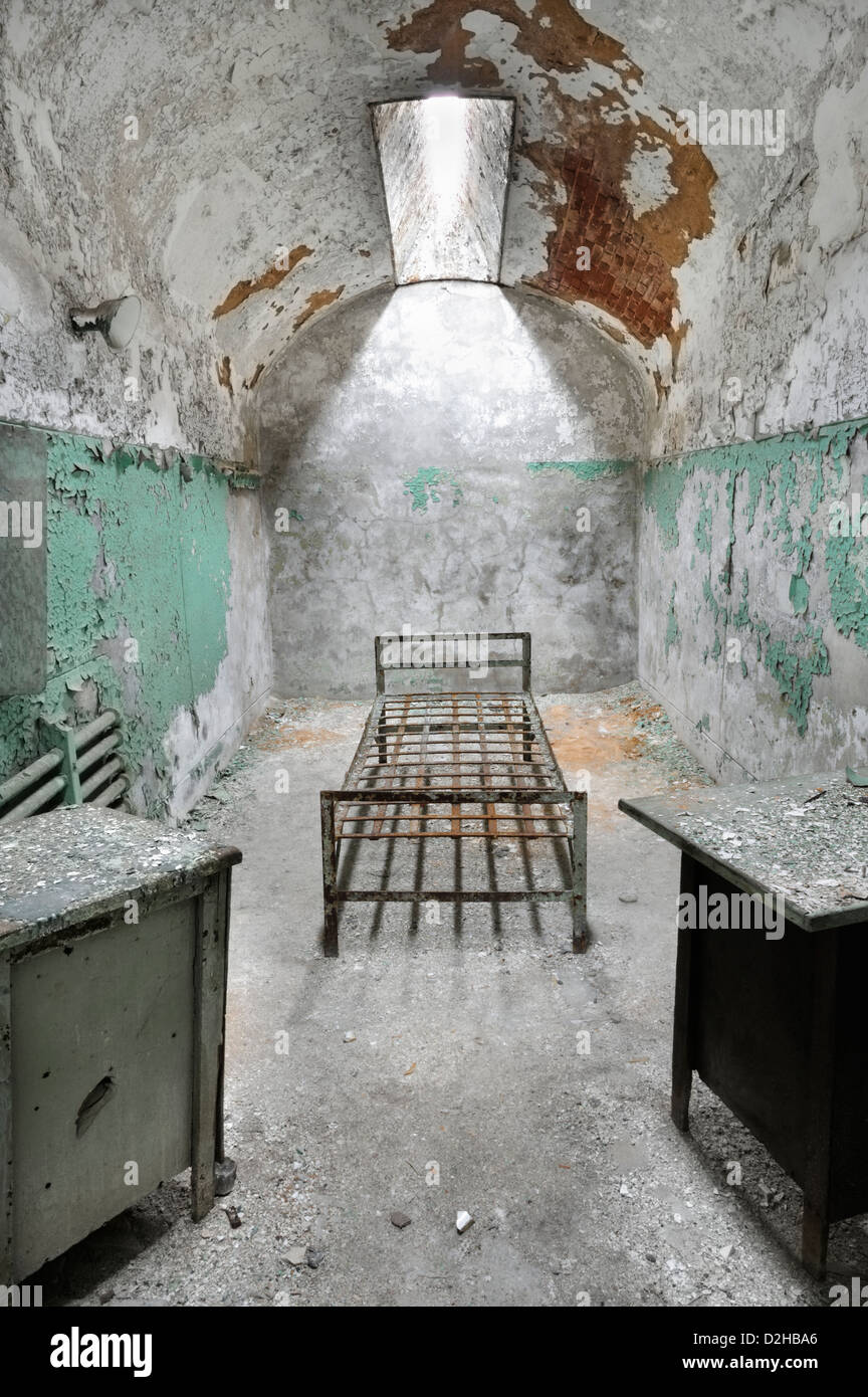 Prison cell with skylight containing bed and tables at abandoned  Eastern State Penitentiary, Philadelphia, PA, Stock Photo