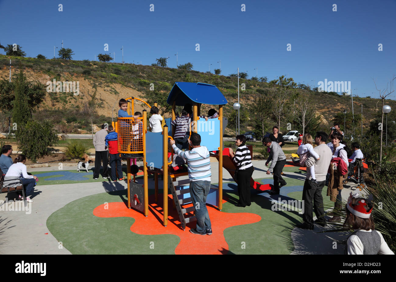 Parents with their children on a crowded playground. Estepona, Andalusia, Spain Stock Photo