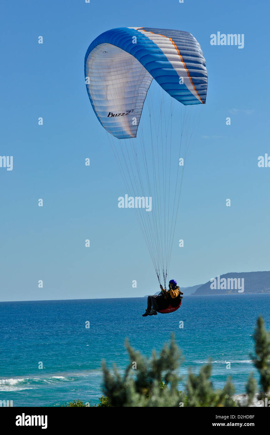 Man parasailing over a beach on the Great Ocean Road near Lorne in Victoria Australia Stock Photo