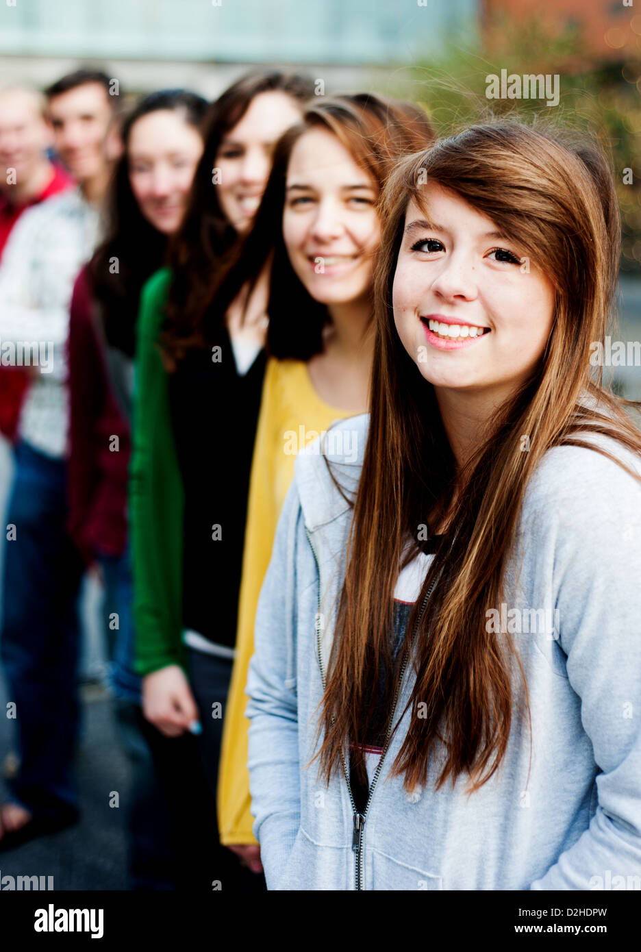 Friends or students outside in a row smiling Stock Photo