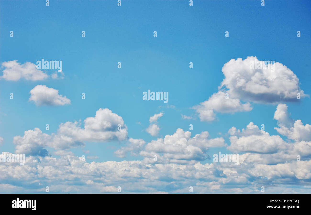 Blue sky with fluffy white clouds. Wide format. Photographic Image. Stock Photo