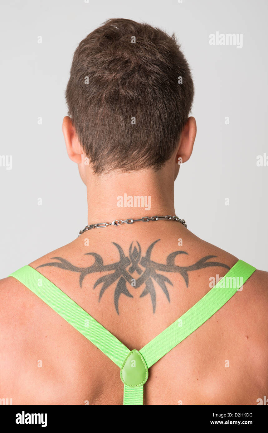Rear view of shirtless man with tattoo wearing suspenders Stock Photo