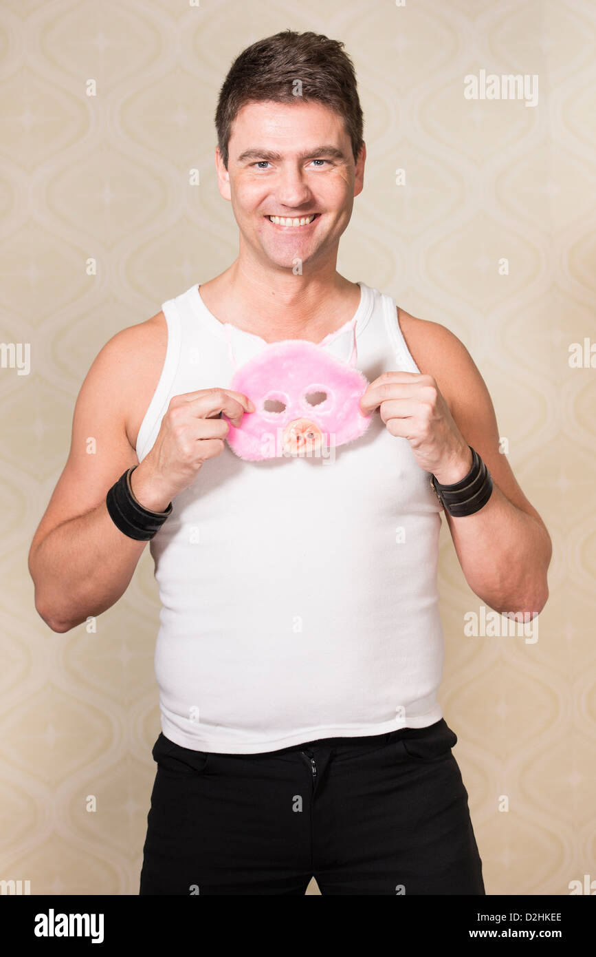 Happy adult male with pig mask smiling and looking at camera Stock Photo