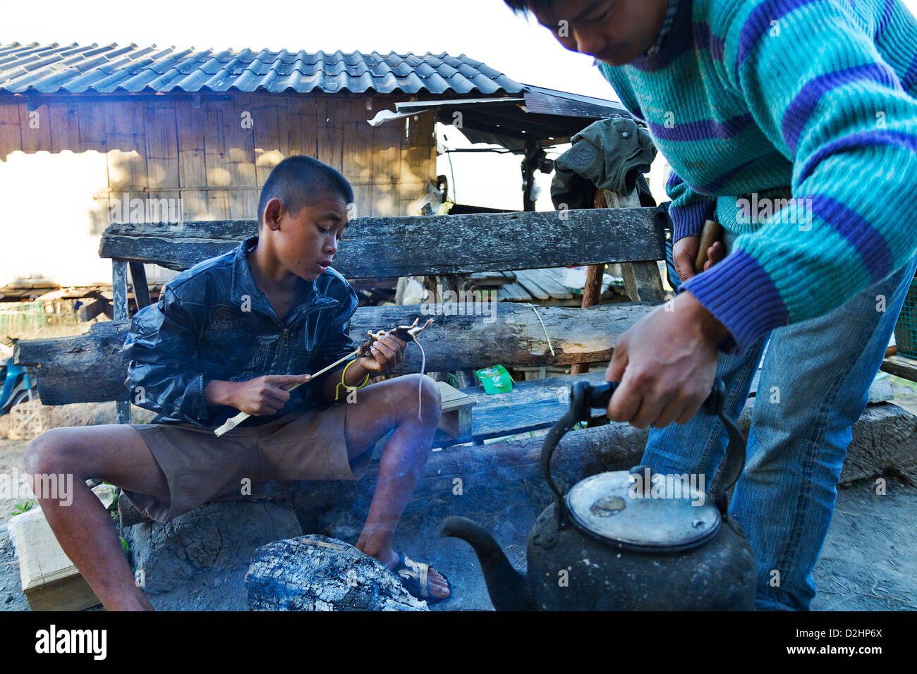 Back to the hunt, a boy prepares to roast a rat Stock Photo