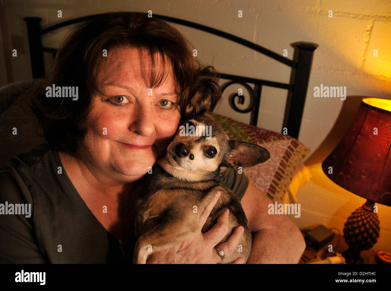 A chronically ill senior patient holds her pet dog. Stock Photo