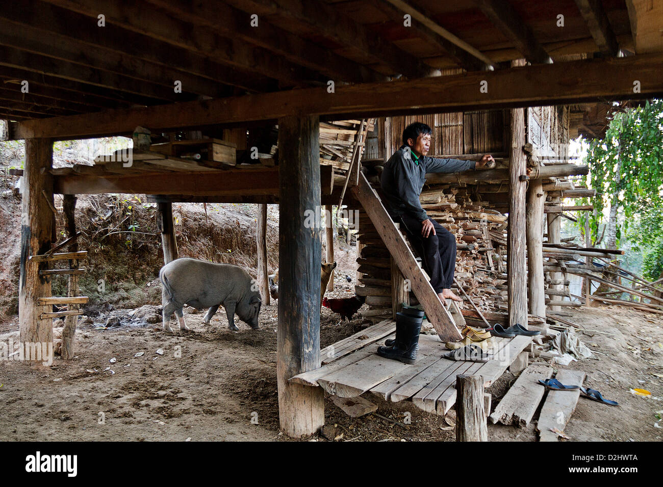 A man in the entrance of a simple house, village in the mountains. Chiang Mai Province, Stock Photo