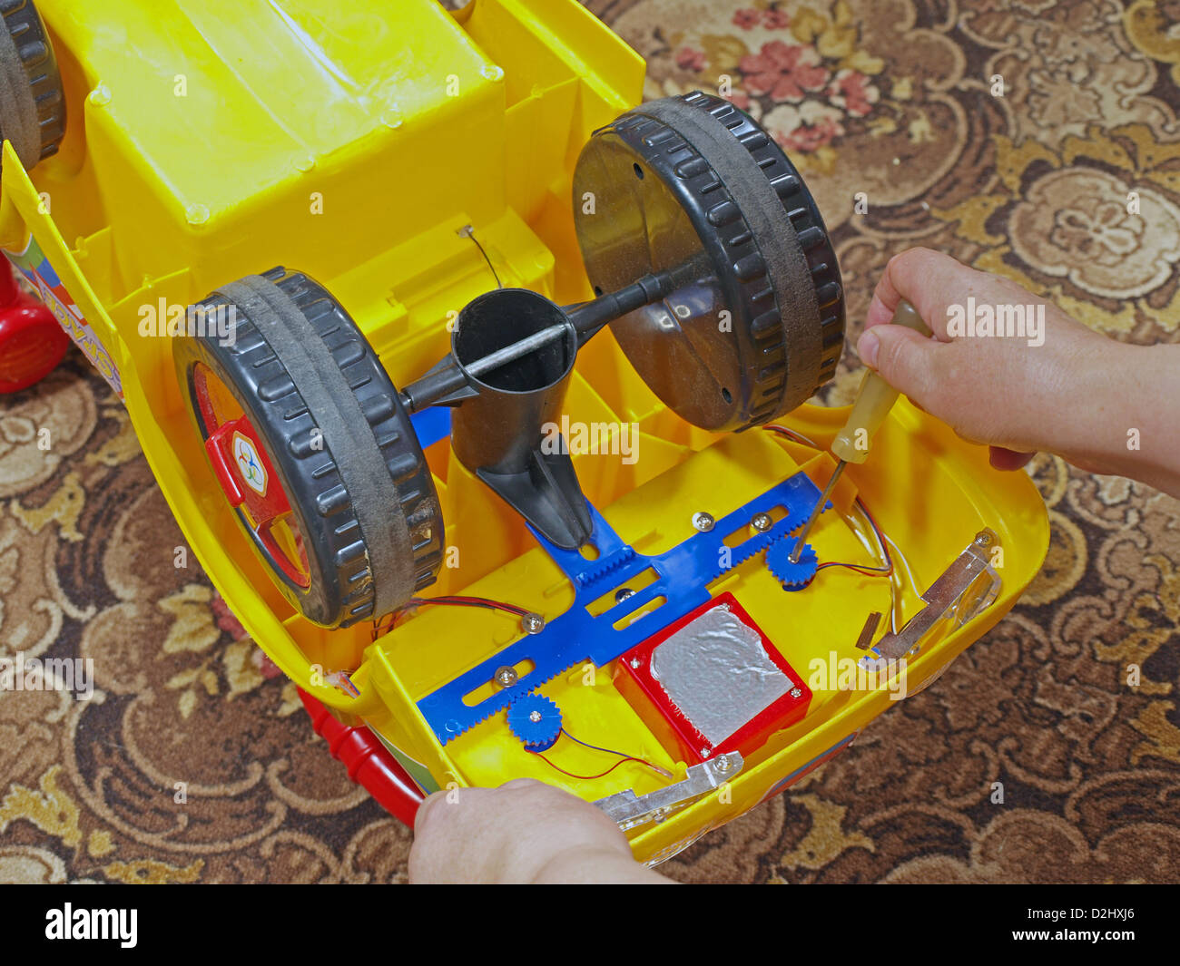 Repairing plastic toy car with screwdriver, close up Stock Photo