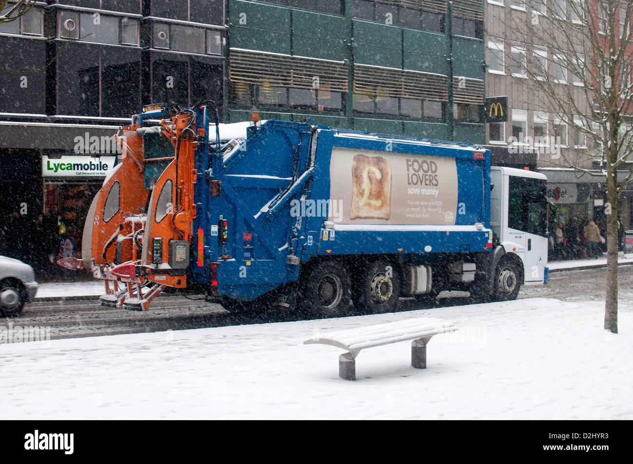 Refuse collection vehicle in snowy weather, Coventry city centre, UK Stock Photo