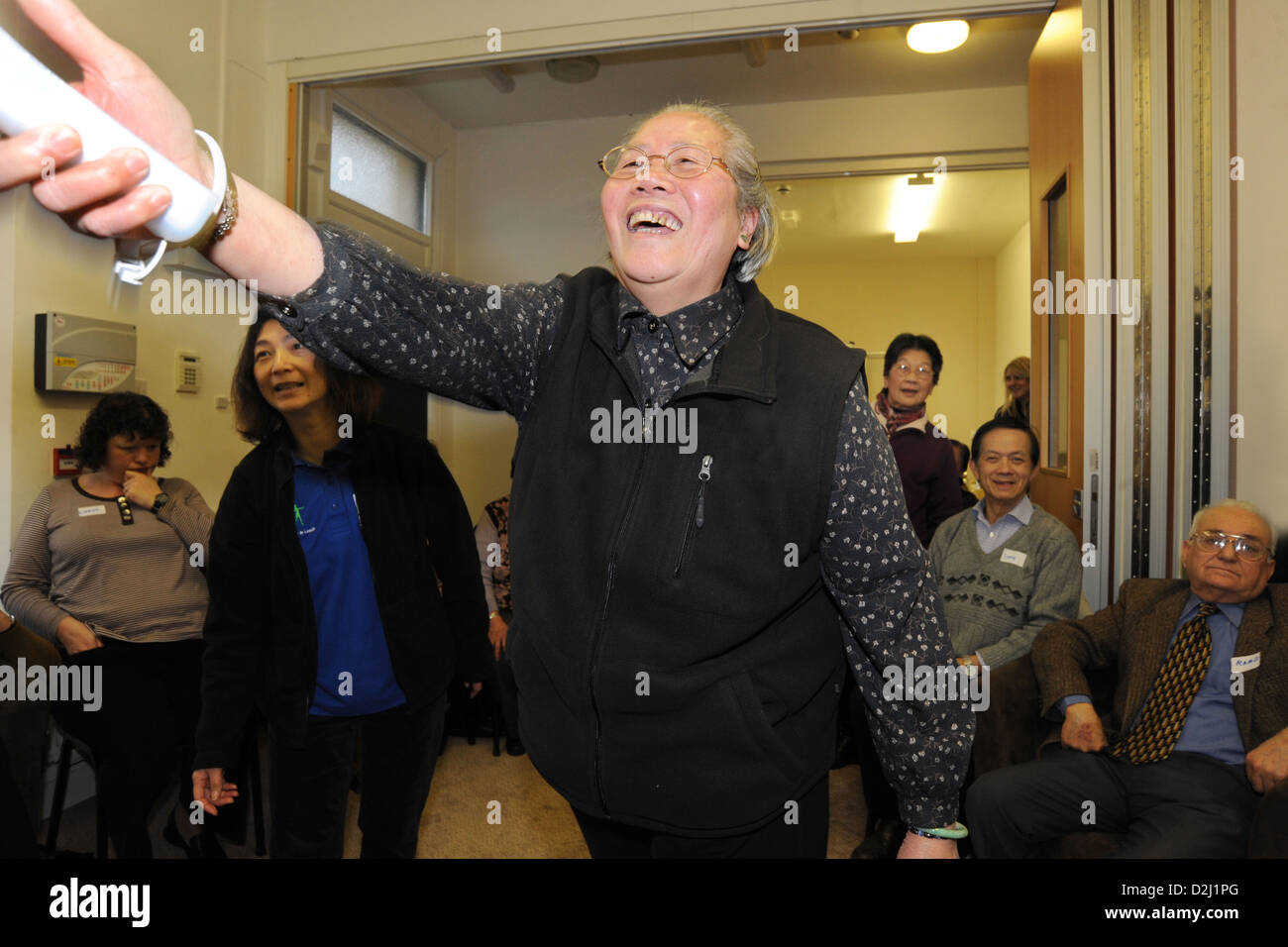 An elderly lady plays bowling on the Wii . Active Project with the Chinese Community, Leeds. Stock Photo