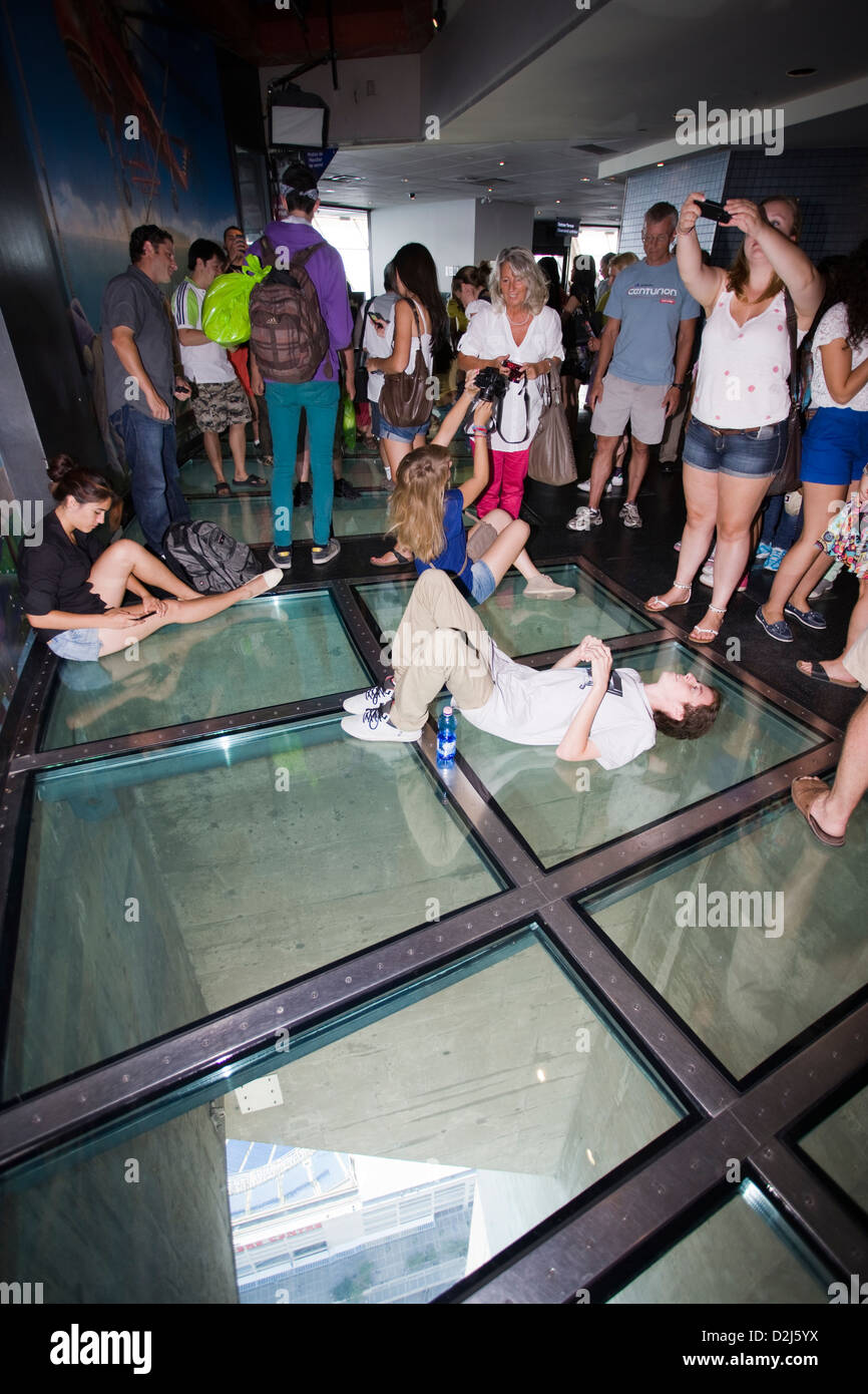 People standing on the glass floor of the CN Tower's viewing deck in Toronto, Canada Stock Photo