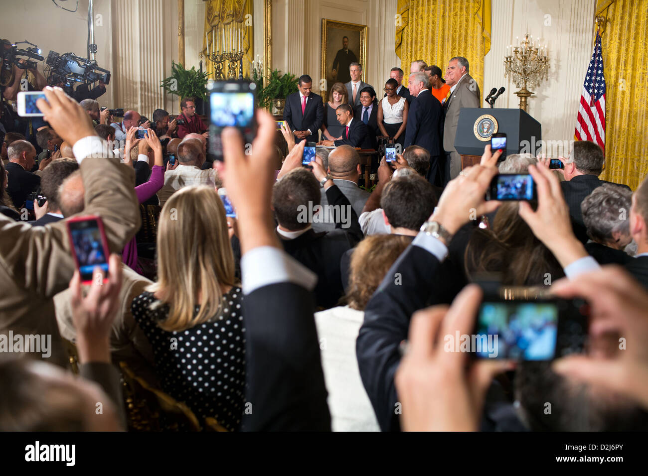 Guests take pictures as President Barack Obama signs HR 4348, the Transportation and Student Loan Interest Rate bill July 6, 2012 during a ceremony in the East Room of the White House. Stock Photo