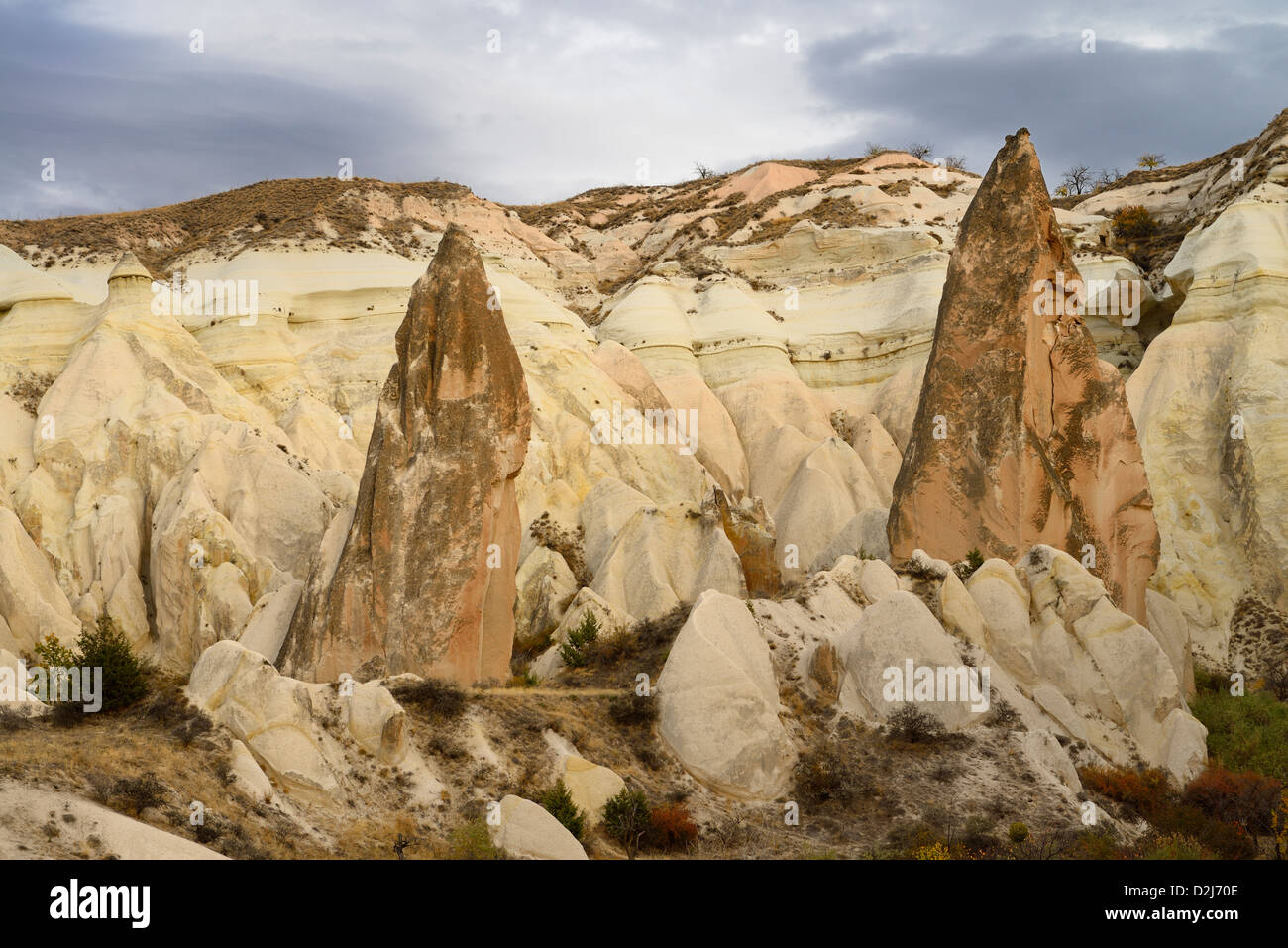 Red pointed Rocks among eroded yellow tuff in the Red Valley Cappadocia Turkey Stock Photo