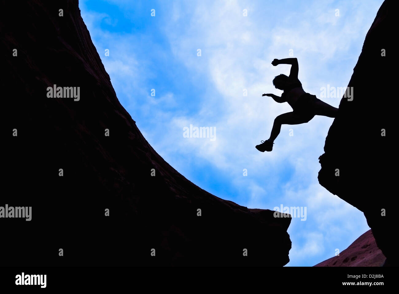 Woman jumping across a canyon gap; san rafael swell utah united states of america Stock Photo