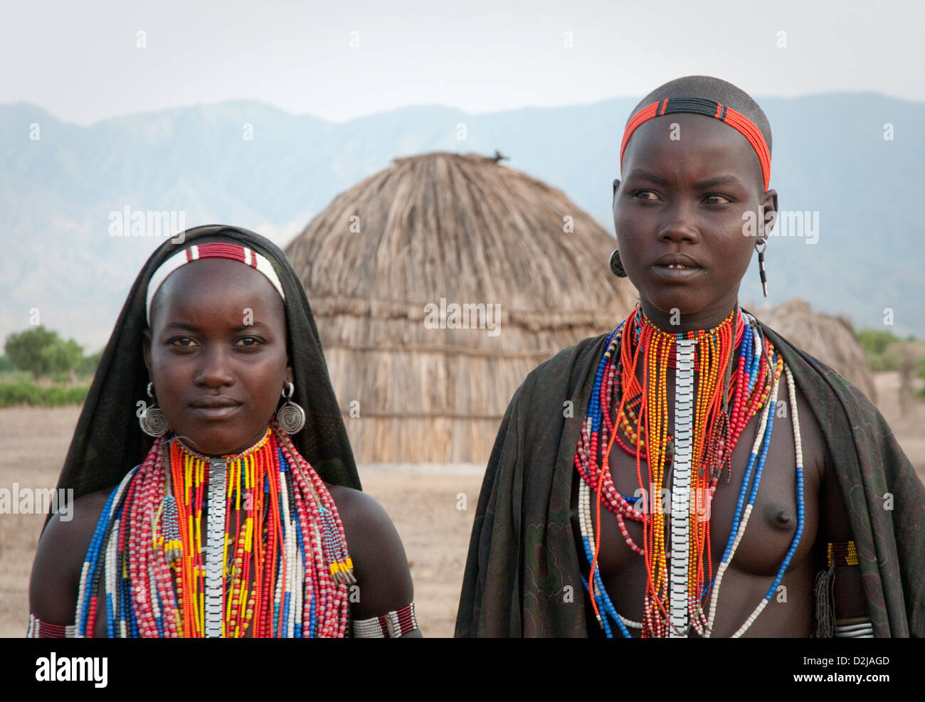 Portrait of two Arbore women with hut in the background Stock Photo