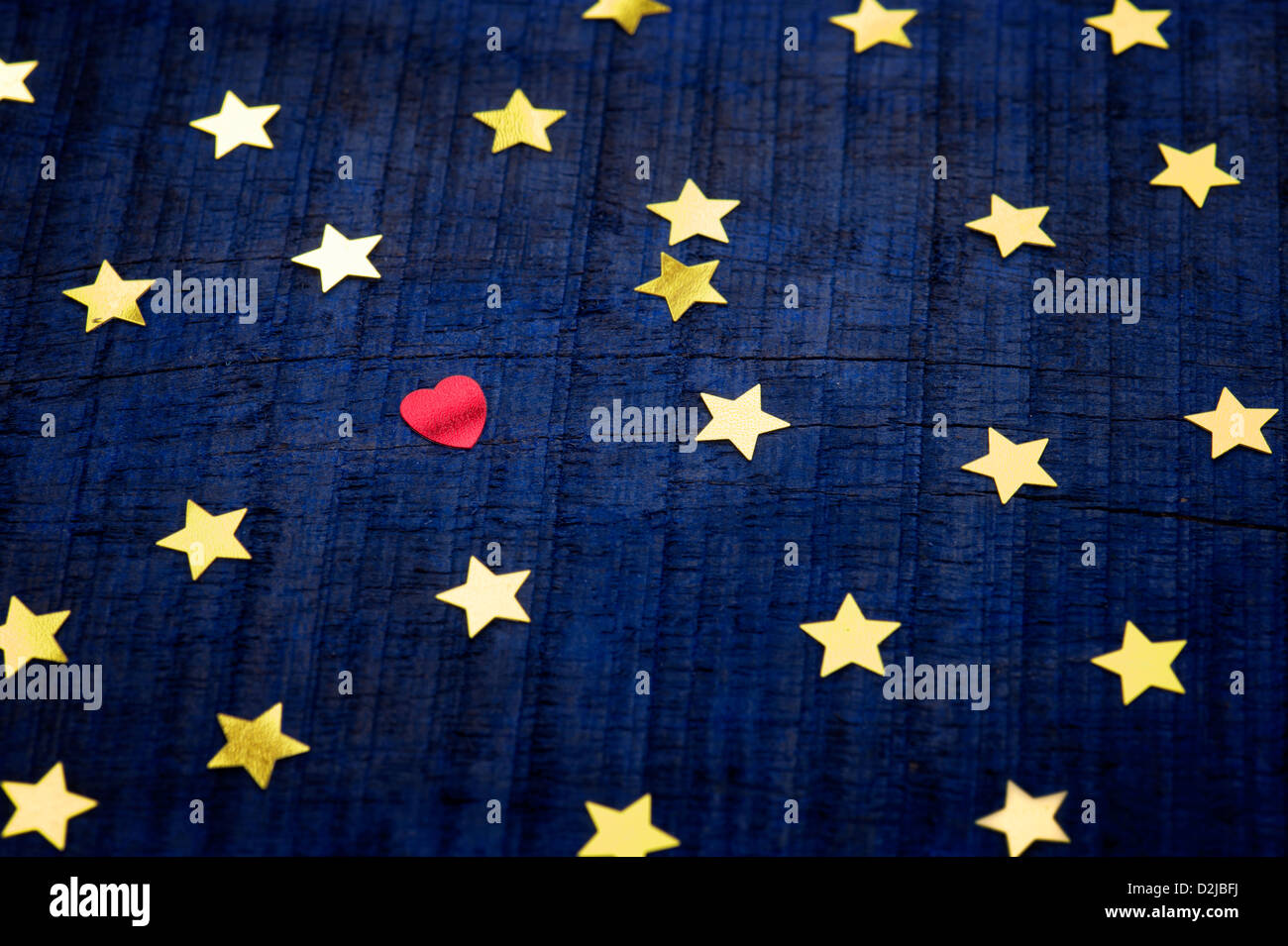 Shiny gold stars and red love heart on a blue wood background Stock Photo