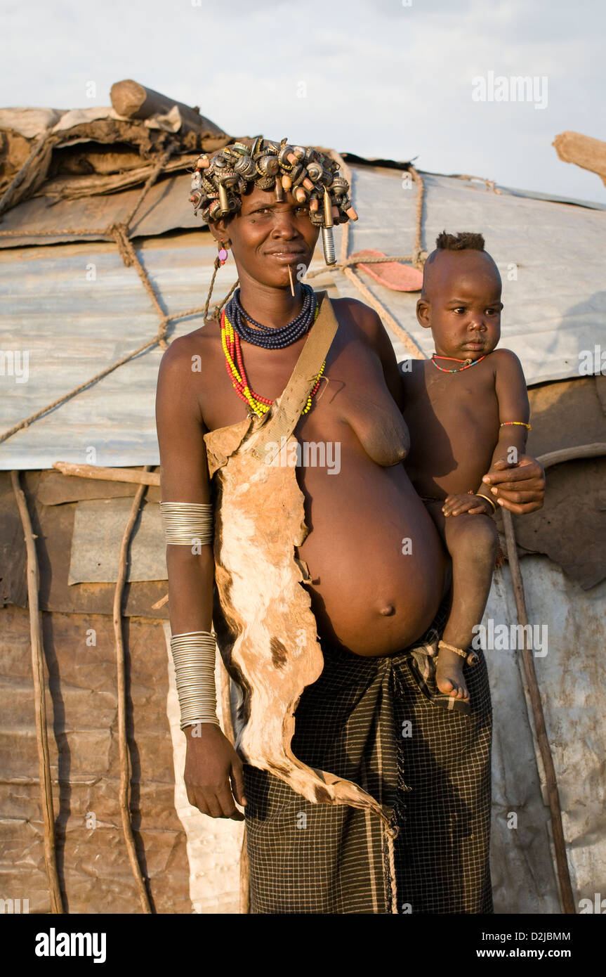 Pregnant Dassenech woman holding baby in arms Stock Photo