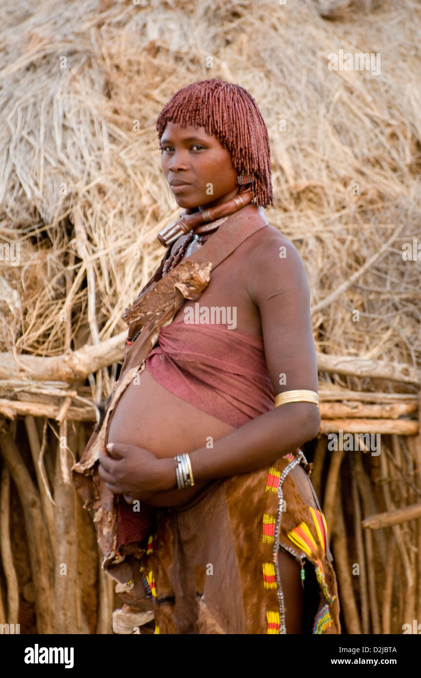 Hamar pregnant woman standing in front of hut Stock Photo