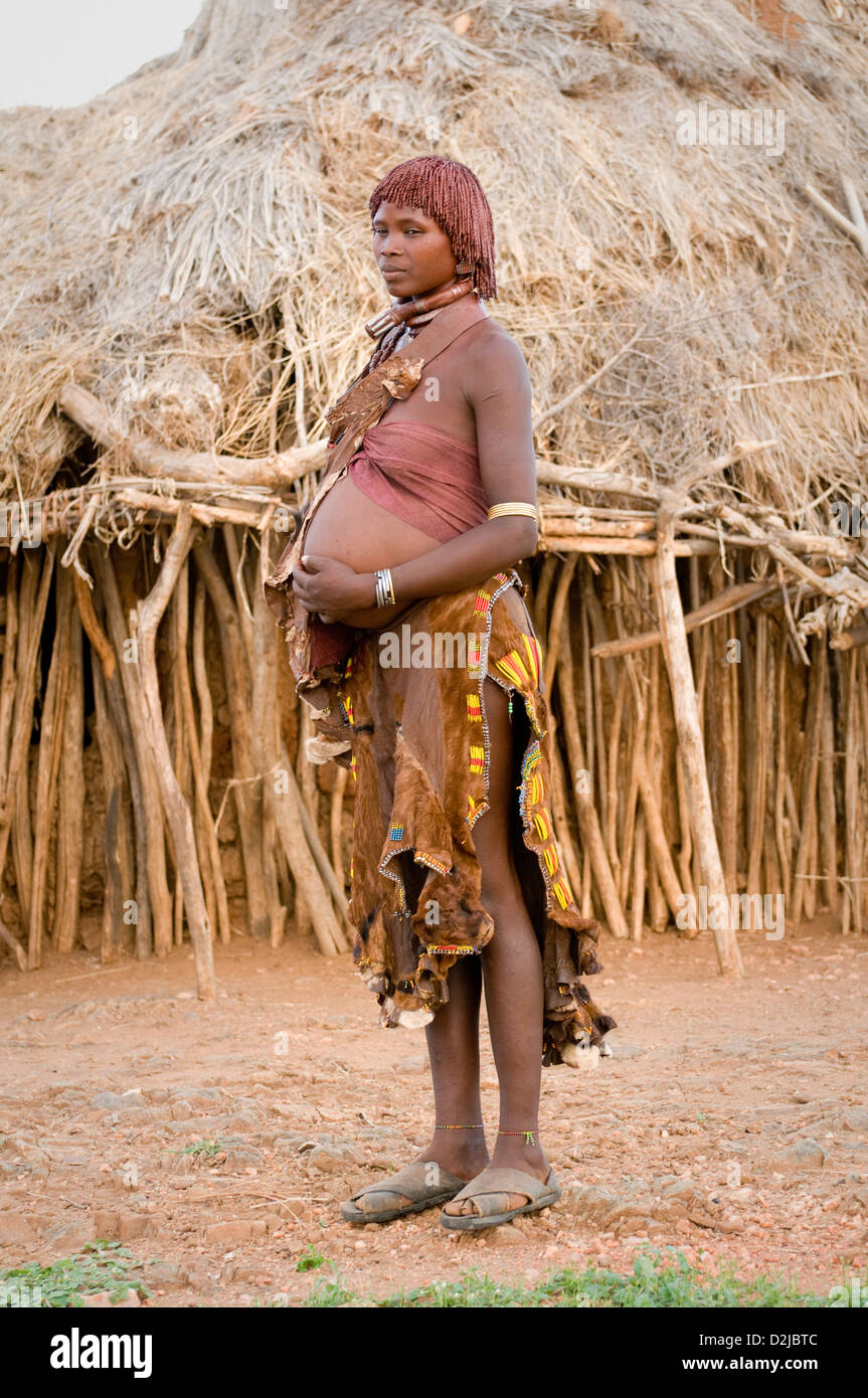 Hamar pregnant woman standing in front of hut Stock Photo