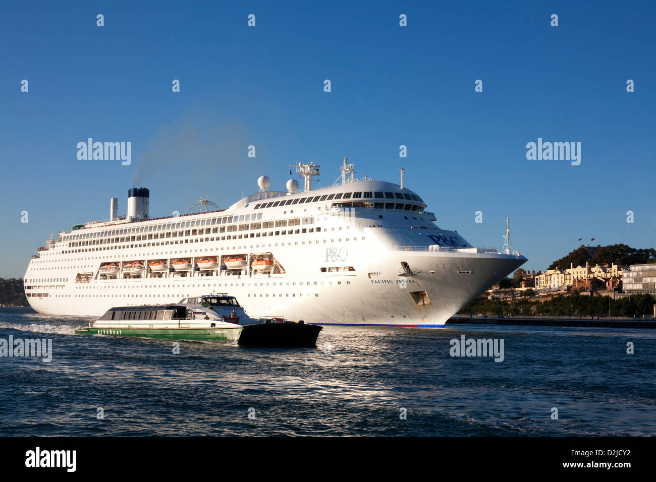 Sydney Harbour Ferry passing P&O Cruises superliner Pacific Jewel Cruise Ship as she departs from Sydney Australia Stock Photo