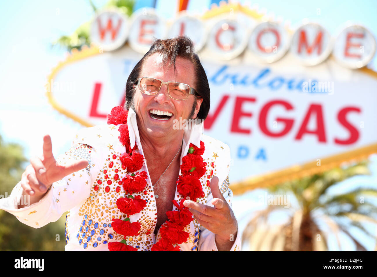 Las Vegas Elvis impersonator laughing having fun in front of Welcome to Fabulous Las Vegas sign Stock Photo