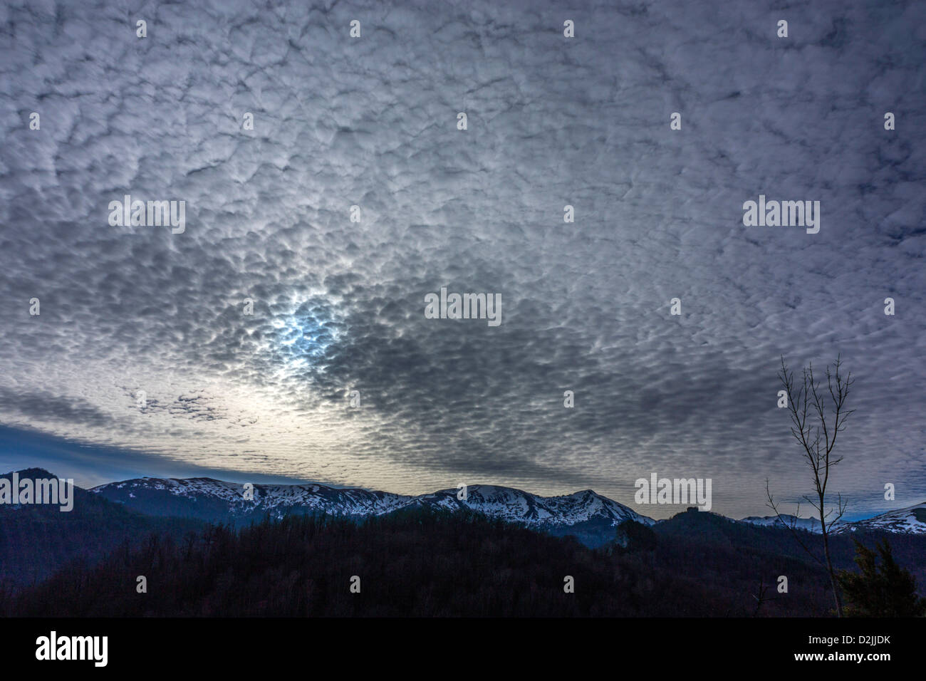 Winter mackerel sky with Altocumulus clouds and snowy mountains Stock Photo