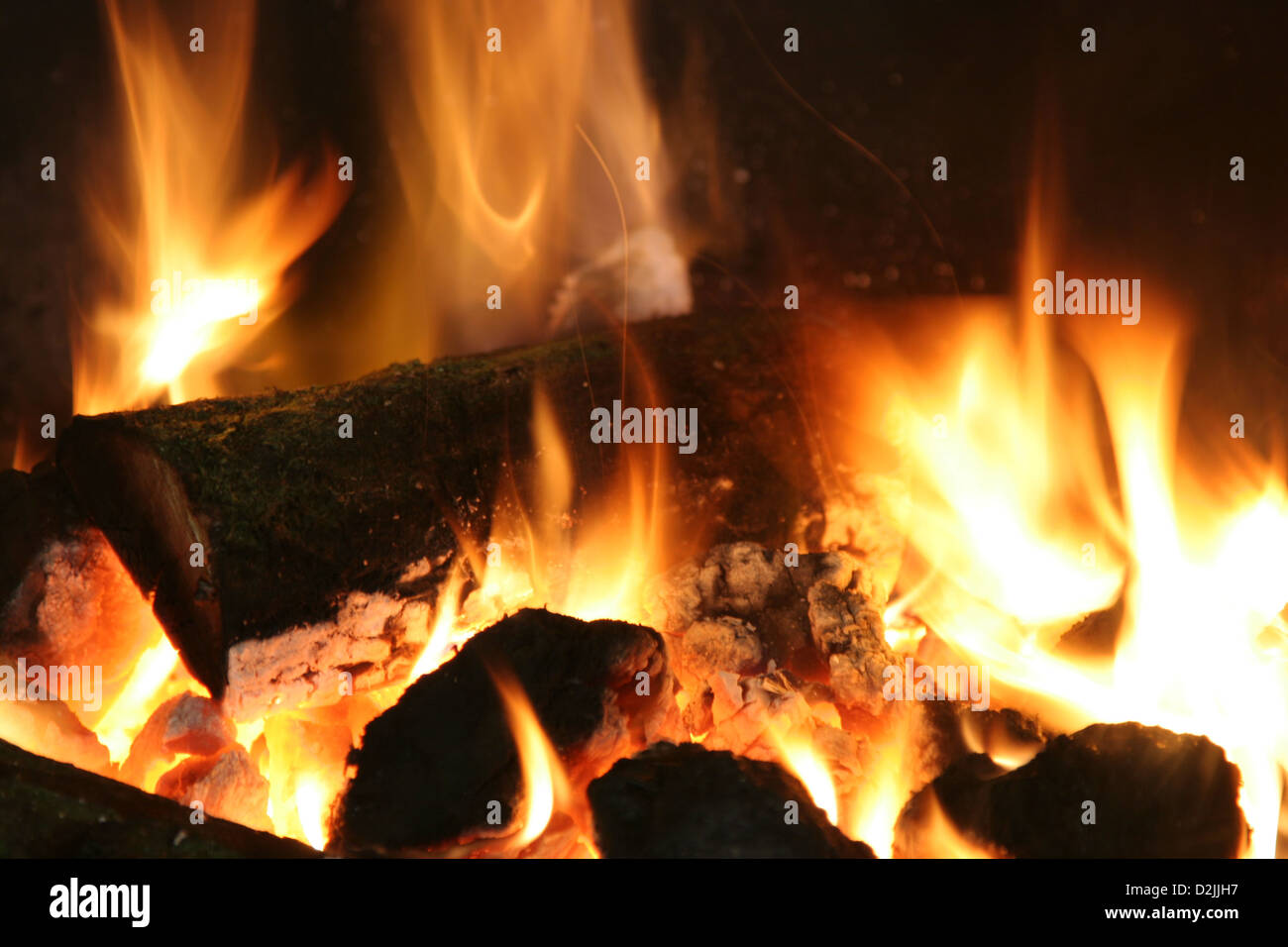 A roaring, orange and red close up of a log fire Stock Photo