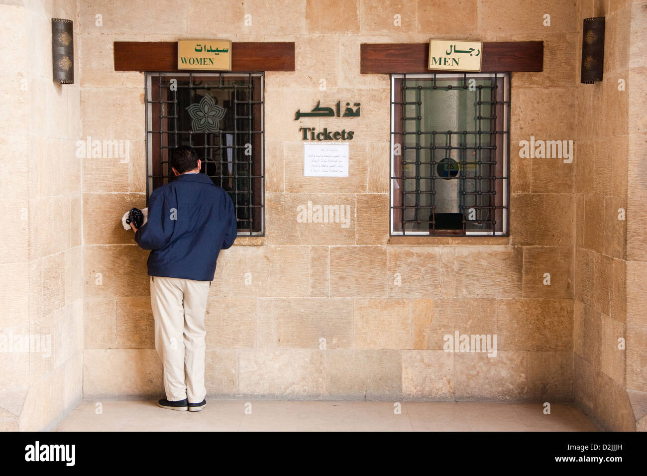 Azhar Box Cairo, Egypt, a man at the box office of the Al-Azhar Park separated by ...
