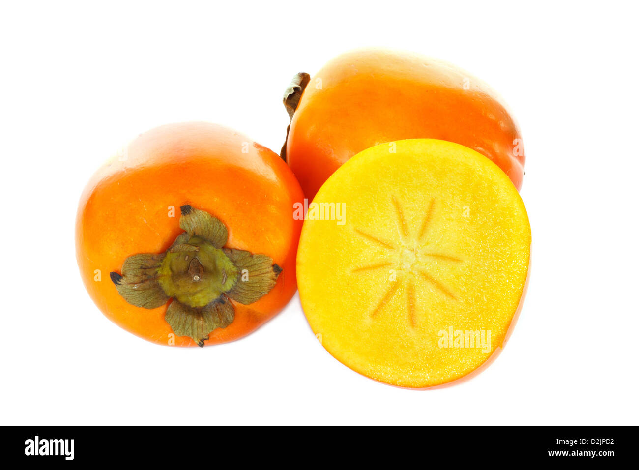 Three kaki fruits, one cut in half against white background Stock Photo
