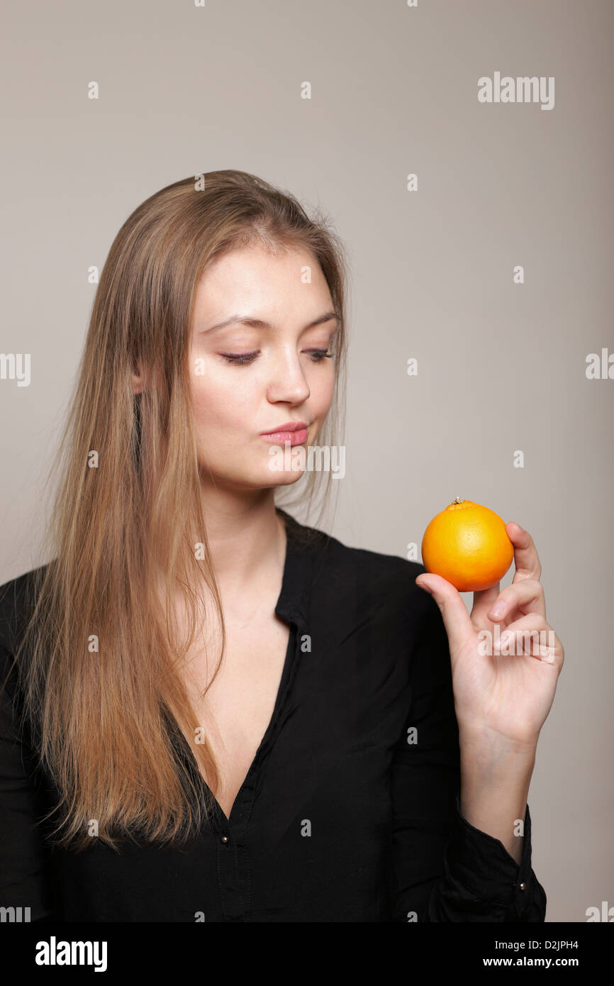 Girl holding orange Stock Photo - Alamy