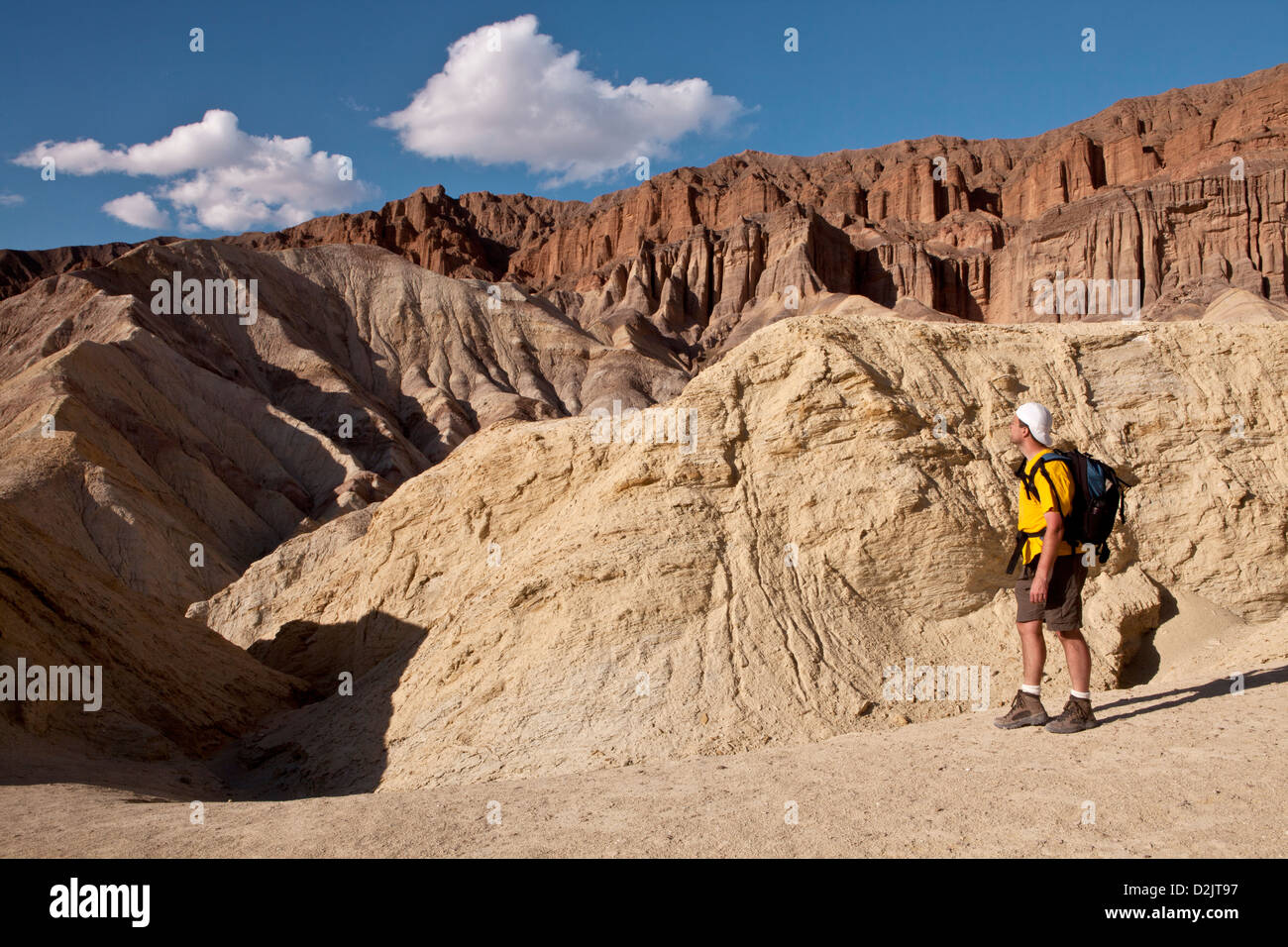 A hiker looks out over the Black Mountains during an evening hike of Golden Canyon in Death Valley National Park, California. Stock Photo