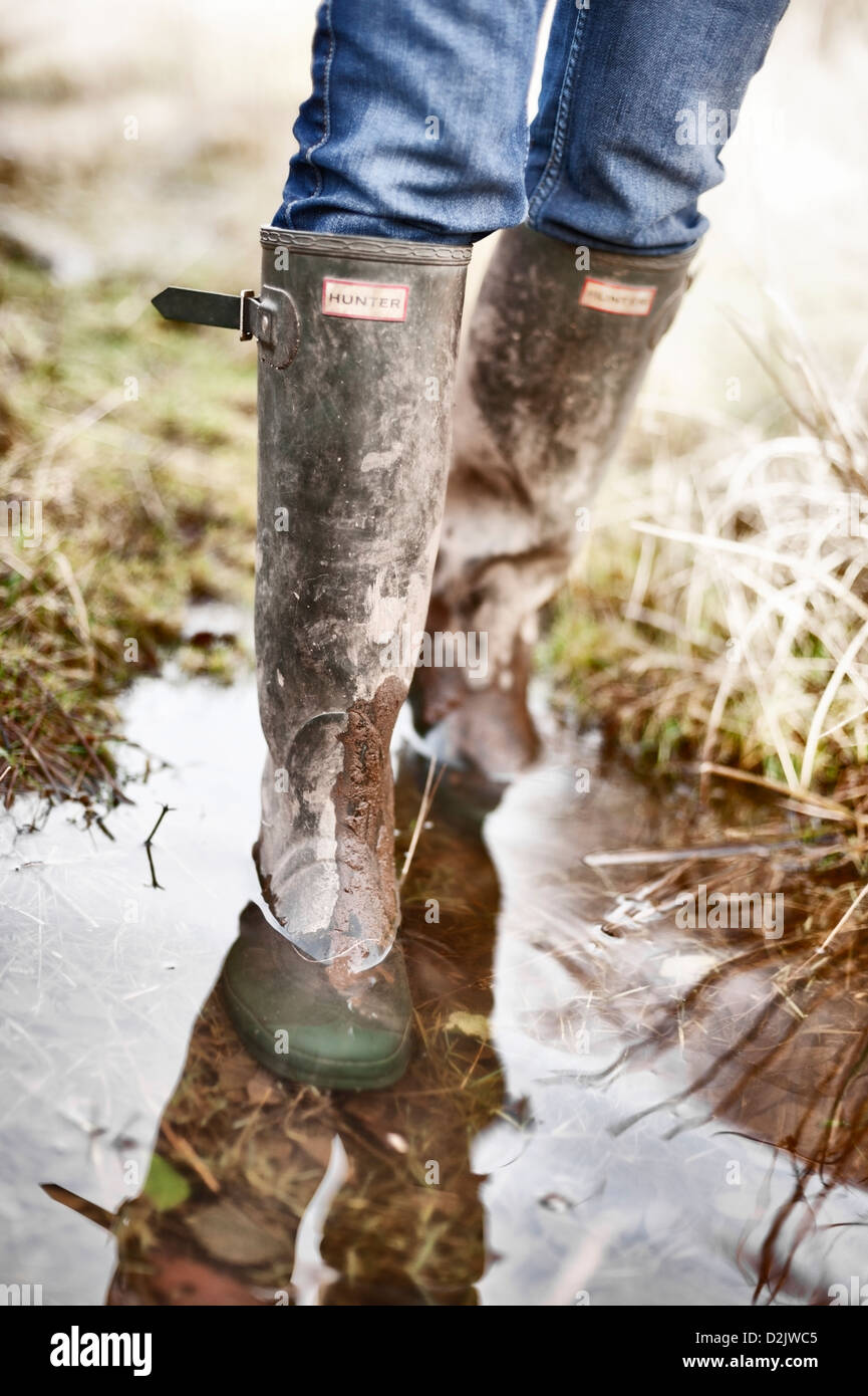 Green Hunter (brand) wellies - wellington boots in wet muddy field Stock Photo