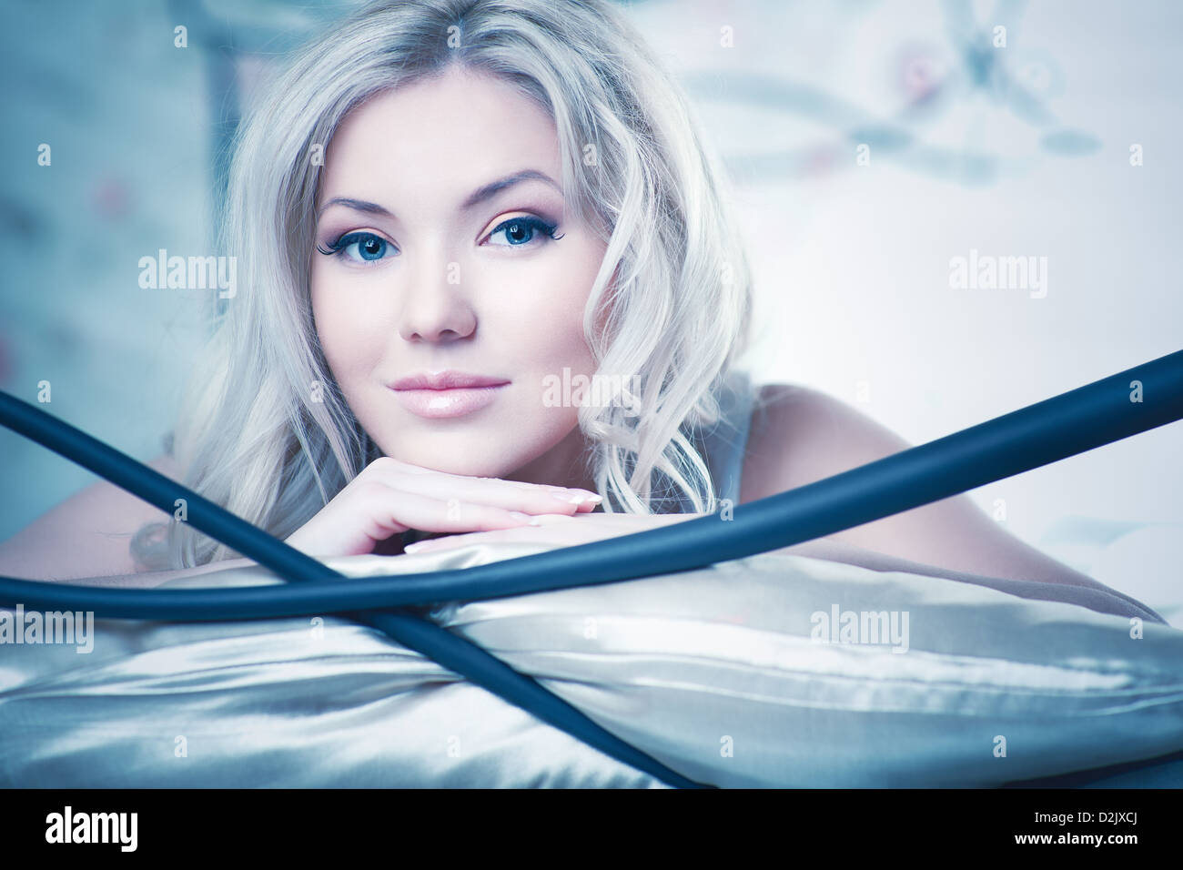 Young woman in bed. White and blue colors. Stock Photo