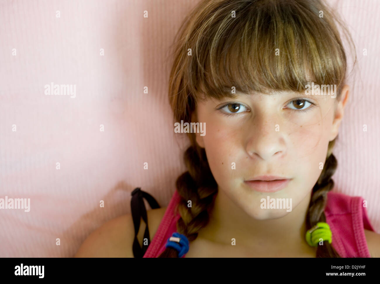 Photo of an attractive preteen girl in pink tank top on a pink