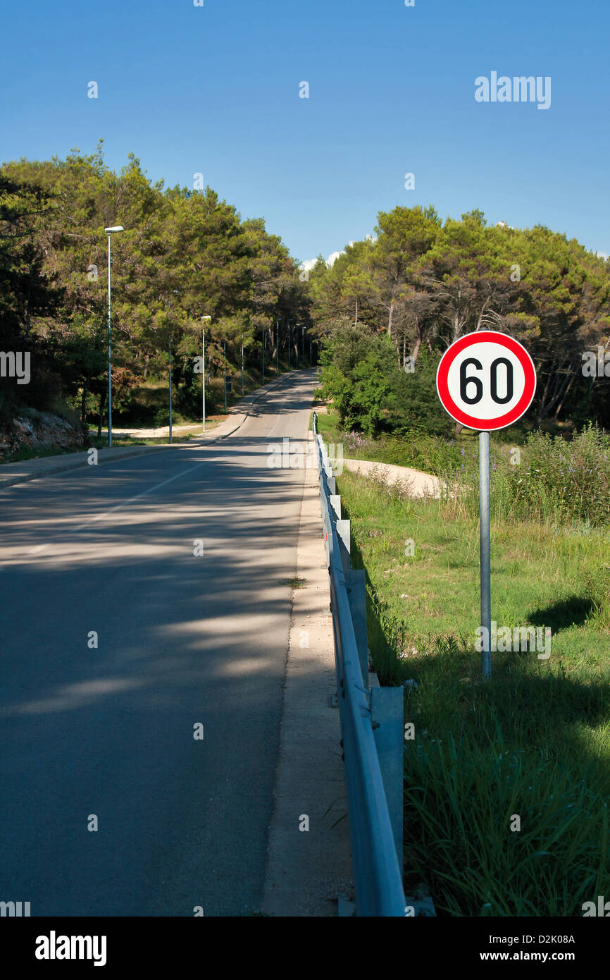 Countryside road by forest, 60 speed limit sign Stock Photo