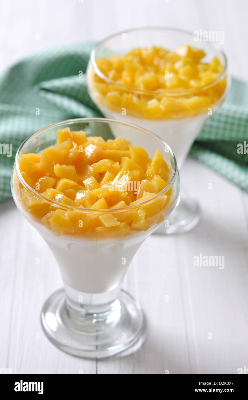 Dessert with peach in a glass on white background Stock Photo