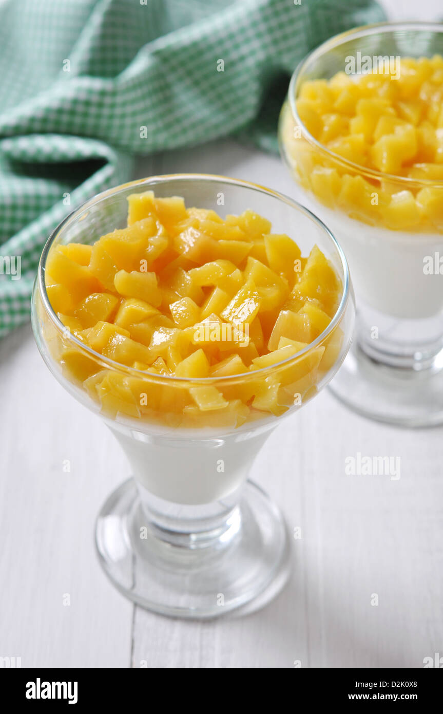 Dessert with peach in a glass on wooden background Stock Photo