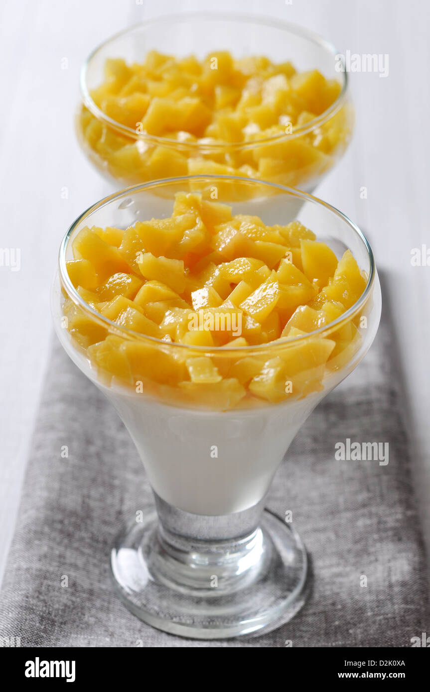 Italian dessert Panna cotta with peach in glasses Stock Photo